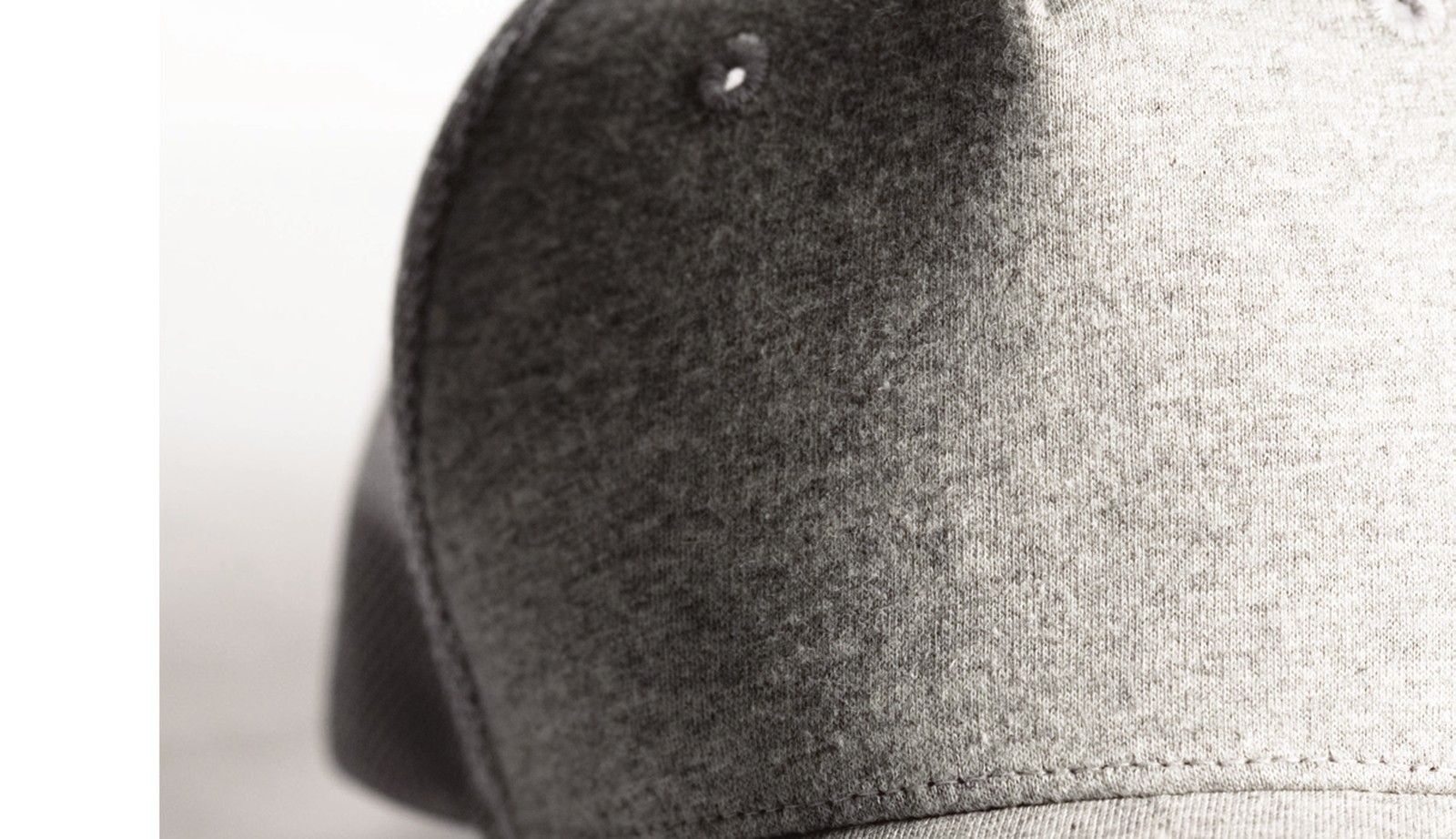 Close view of a wool melton six-panel cap, showing crown seams and a sewn eyelet