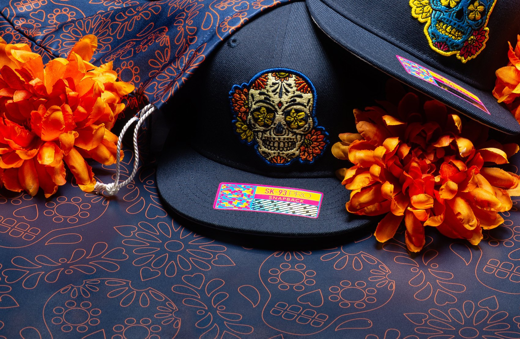 Embroidered appliqué patches on wool snapback crowns, with a printed cotton bandana